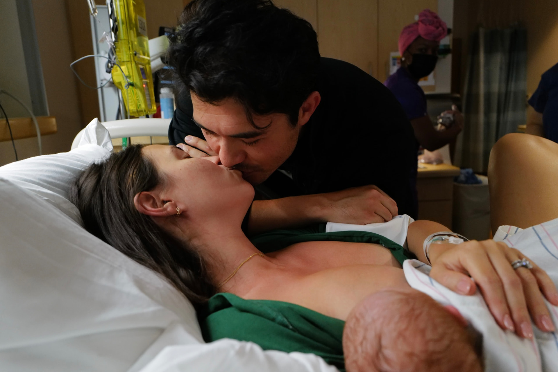 Liv Golding in a hospital bed after birth, holding her newborn against her chest